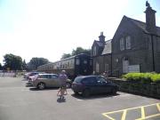 The former Border Counties station at Bellingham in July 2013. The station closed to passengers in 1956, with the line back to Reedsmouth finally abandoned in 1963. The station building was subsequently put to use as Council offices. Behind the camera is Bellingham Heritage Centre. The coaches provide additional exhibition space and tea room facilities.<br><br>[John Yellowlees 06/07/2013]