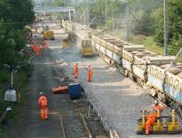 Fresh ballast being laid on 18 July before being roughly levelled by the bulldozer. The bed is finally prepared for the new track panels using the bank of remote controlled vibration packing machines bottom right. Unfortunately one of the three was not behaving and is about to be removed for corrective treatment so that packing could continue.<br><br>[John McIntyre 18/07/2013]