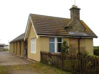 A close up view of the former Hopeman Station building looking towards Burghead in June 2013, with the trackbed on the left fenced off from the platform. [See image 35161]<br><br>[David Pesterfield 24/06/2013]