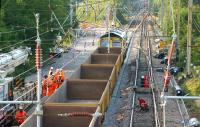 The Balshaw Lane worksite on 18 July with a Kirow crane positioning another panel of track on the Down Slow. 66555 moves over the newly completed Down Fast and the gas axe team continues cutting rails on the Up line which will shortly be loaded into the empty wagons.<br><br>[John McIntyre 18/07/2013]