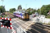 Northern Sprinter <I>Bubble Car</I> 153360 rolls across Bare Lane and into the station of the same name on a service for Lancaster. The crossing barriers seen here are now controlled from Preston Power Box. This view taken on 16 July from the now closed (and later demolished) signal box, with kind permission, looks towards Morecambe. <br><br>[Mark Bartlett 16/07/2013]