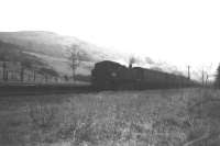 A Wemyss Bay - Glasgow train passing the remains of Ravenscraig station, south west of Greenock, in February 1966. The station, opened in 1865, once served the former Smithston poor-house and asylum. During WWII, it became the British headquarters of the Royal Canadian Navy and carried the name HMCS <I>Niobe</I>. The station was closed in February 1944. [With thanks to Messrs Leiper, McTaggart, Dunbar, Robin, Baillie, Jamieson & McIntosh]<br><br>[Colin Miller /02/1966]