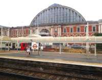 Looking south west across the running lines at Kensington Olympia on 20 July towards the main hall of the exhibition centre. A District Line train for High Street Kensington stands in the bay platform.<br><br>[John Thorn 20/07/2013]