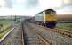 The severed link at Crediton in 1985. View west showing the disconnected double track to Newton St Cyres. The class 47 is hauling a Meldon Quarry to Exeter Riverside ballast train.<br><br>[Ian Dinmore //1985]