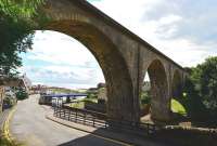 The Fife coastal village of Largo was served by the railway that ran from Thornton Junction to St Andrews. The line was a victim of the Beeching cuts, closing in stages between 1965 and 1969. The surviving four arch viaduct, seen here looking west in July 2013, is still a landmark in the village. It spans the Hatton Burn and seems to be in good condition. Both ends are fenced off, so there is no public access. The nearest arch frames Largo Harbour, with the Firth of Forth in the distance.<br><br>[John Gray 30/07/2013]