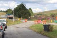 View north from the lay-by at Falahill on 30 July 2013 with the Waverley trackbed on the far right and the A7 running across the picture. Falahill cottages are hidden by the trees. Work planned here is currently described on the Transport Scotland website as follows... <I> The proposed development involves reinstating the Borders Railway .... and realigning the A7 to the east of Falahill cottages. The realigned road will cross the railway using a simple bridge structure.</I> [Update - an alternate planning proposal is now under consideration which would see the A7 staying close to its present course - August 2013] <br><br>[John Furnevel 30/07/2013]