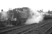 Shrouded in steam, a member of the footplate crew climbs back on board Ivatt 4MT 2-6-0 no 43129 at Bellingham on 9 November 1963. The locomotive has just run round <I>The Wansbeck Wanderer</I> and is preparing to return to Reedsmouth. The special will later visit the Rothbury branch [see image 31617] before heading back to Newcastle via Morpeth.<br><br>[K A Gray 09/11/1963]