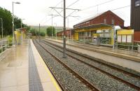 New Hey on the Oldham loop has undergone quite a transformation since my last visit in 2009. With the closure of the railway, which by then had been reduced to a single line between Shaw & Crompton and Rochdale [see image 21080], the conversion to Metrolink tram has seen most of the route returning to double track. On a wet 31 July 2013, the former L&YR Cotton Warehouse stands over the tram stop as a reminder of times past.<br><br>[John McIntyre 31/07/2013]