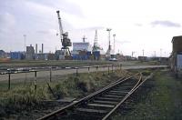 A southerly view along Griffin Wharf at Ipswich on 5th March 1983. The foreground siding served Ransomes Waterside works and showed signs of recent use at the time of the photo. The tracks running to the left were in more regular use serving the freightliner terminal seen in the background. Subsequently, the freightliner traffic was replaced by aggregate traffic and the works was closed and demolished.<br><br>[Mark Dufton 05/03/1983]