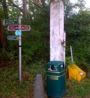 This is what we want on a bikepath on a disused railway! An old crossing gatepost, lots of clear signposting, and, goodness me, a litter bin. Perhaps the council even arranged the gorgeous dappled sunlight through the trees? Location is Leasey Bridge Lane.<br><br>[Ken Strachan 09/08/2013]