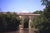 Part of Germany's longest stone-arch viaduct, spanning the Lausitzer Neisse river at Goerlitz between Germany and Poland. Built between 1844 and 1847, the viaduct has 30 arches, is 35m high and 475m long, and was partly destroyed by bombing in the closing weeks of World War 2. Here the 06.35 Wroclaw (formerly Breslau) to Dresden Regional-Express inches past engineering work on 4th July 2013.<br><br>[David Spaven 04/07/2013]