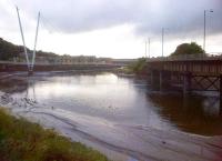 Three bridges at Lancaster. A Pendolino can just be seen on the WCML bridge over the River Lune in the background, while the Churchillian salute on the left is a support for the pedestrian Millennium Bridge. The road bridge on the right was formerly the rail bridge for the line from Green Ayre to Morecambe. The fourth bridge is out of shot - I was standing on the curved and rising viaduct carrying the link from Green Ayre to Castle station [see image 19357].<br><br>[Ken Strachan 29/07/2013]