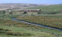 A class 156 forming the 08.28 ex-Glasgow Central heads for Stranraer at Glenwhilly on a fine early spring day in 2002.<br><br>[Bill Jamieson 30/03/2002]