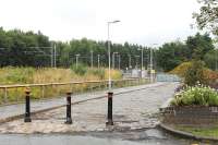 Oldham Mumps was (almost) completely demolished after closure in 2009. This temporary replacement tram stop was on the Manchester side of the old station. Alongside the part cobbled approach to the tram stop the remains of an old platform face could still be seen in July 2013. These last railway remnants will go when the Oldham street running section is completed in 2014 and the railway land is redeveloped.<br><br>[Mark Bartlett 31/07/2013]