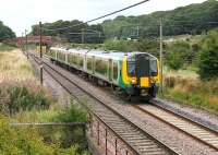 Glasgow/Edinburgh to Manchester Airport services move to EMU operation from December 2013 and, ahead of that, TransPennine has hired a London Midland Class 350 for driver training between Preston and Carlisle. The unit stables in Preston and makes up to three return trips on weekdays. The green, grey and black 350252 makes an unusual sight in Lancashire, seen approaching Woodacre on 30 August. <br><br>[Mark Bartlett 30/08/2013]