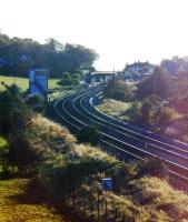 Looking south from the Dalry Road bridge towards West Kilbride station in the early 1980s, showing the up home signal (and in the distance the starter) off, the two platforms and the covered footbridge.<br><br>[Colin Miller //]