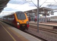 A Voyager heads south empty stock through Rugby platform 4, while passengers await a Pendolino on platform 5.<br><br>[Ken Strachan 30/08/2013]