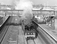 92220 <I>Evening Star</I> storms under the footbridge at Church Fenton with <I>ThePennine Ranger</I>on 29th October 1977. Organised by the Midland & Great Northern Joint Railway Society, the tour started at Euston and ran via Rugby and Leicester to York where 92220 took over as far as Leeds, giving way to Sir Nigel Gresley for the next leg on to Carnforth. This was one of two steam tours run that day - 92220 later worked <I>ThePennine Venturer</I>, which had originated in Cardiff, between Leeds and York (also via Church Fenton). [With thanks to Vic Smith]<br><br>[Bill Jamieson 29/10/2007]