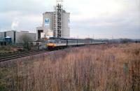 Scene on the Rutherglen & Coatbridge line at Carmyle in 1988, with trains being temporarily diverted from the E&G route. An unidentified ScotRail class 47/7 takes an eastbound service past the site once occupied by the Clyde Ironworks.<br><br>[Ewan Crawford //1988]