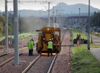 Looking east from Edinburgh Park on 23 September 2013 with Arthurs Seat dominating the horizon. A rail grinder is hard at work on the section of track just beyond the tram stop.<br><br>[Bill Roberton 23/09/2013]