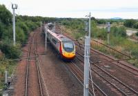 View south from Station Road bridge, Law, Lanarkshire, on 23 September 2013. The 1200 Glasgow Central - London Euston Pendolino speeds south past the site of the former (now demolished) road/rail distribution centre on the right. Beyond the dereliction Tinto Hill stands impassively in the background.  <br><br>[John Furnevel 23/09/2013]