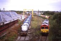 66097 runs round its train of empty whisky tanks and containers at Elgin Yard on 13thSeptember. The platform side of the former GNoSR passenger station has seen better days, but the main building is still in splendid condition. Condemned OTA timber wagons are returning to nature on the background.<br><br>[David Spaven 13/09/2013]