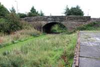 Whitburn station lost its passenger service as long ago as 1930, although the line continued to handle freight well into the 1960s. The trackbed is now part of a walkway, seen here on 23 September looking south towards the bridge carrying the A705 Main Street over the trackbed. The overgrown and unrecognisable station site is on the other side of the bridge [see image 45561].<br><br>[John Furnevel 23/09/2013]