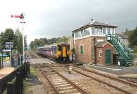 156480, heading for Newcastle, slows for the Haydon Bridge stop as it passes the fine looking signal box that protects the level crossing. Barriers have now replaced the gates that were in use here until comparitively recently [See image 13564].<br><br>[Mark Bartlett 03/10/2013]