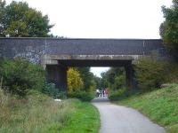 Hawton Lane overbridge, Balderton, Newark, which crosses the long distance national cycle-path 64 running along the solum of the former line running from the East Coast line at Newark to the north side of Melton Mowbray thro' the former ironstone area of the country. There were three curves, two from the west, and east to south, from the Grantham to Nottingham line. View north in October 2013.  <br><br>[David Pesterfield 05/10/2013]