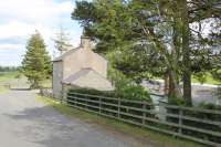 The rear of Staward station, looking down the long stone embankment that is such a prominent feature alongside the Alston to Hexham road. The old platform building, now holiday accommodation, can be seen through the trees. <br><br>[Mark Bartlett 05/06/2013]