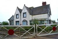 Now a private residence, the former station building at Wickenby on the Lincoln to Barnetby line is seen here on 11 October 2013. The smart set of level crossing gates is controlled from the signal box behind the camera.<br><br>[John McIntyre 11/10/2013]