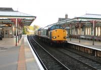 The DRS Crewe to Sellafield flask train runs through a sunny Grange-over-Sands on 17 October. Two EE Type 3s were in charge of the two wagons on this occasion, locomotives 37608 and 37682.<br><br>[Mark Bartlett 17/10/2013]