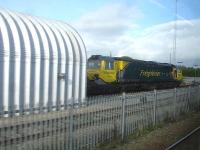 A grab shot from a Cambrian Coast bound Arriva service looking back at Freightliner 70004 standing forward of the class 97 servicing shed on Network Rail's Coton Hill depot. The loco was  attached to a coal wagon which was having its rear bogie checked out.<br><br>[David Pesterfield 17/10/2013]