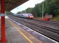 No shortage of reds and yellows as the 08.38 to Euston coasts into Lancaster on 29th July. I seem to remember from my schooldays that the steel frame on the right is used to train rugby players to scrum down. Nice platelayer's hut standing beyond.<br><br>[Ken Strachan 29/07/2013]