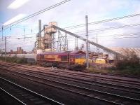 Grab shot from a passing train on 23 October showing EWS liveried 66179 on a rake of Construction Sector aggregate hopper wagons being unloaded at Tarmac's Hayes and Harlington coating plant on the up side of the Great Western main line.<br><br>[David Pesterfield 23/10/2013]