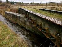 Looking south on 6 November 2011 over the remains of the former rail bridge which carried the closed main line from Edinburgh to Perth over the South Queich River.  The Up span has been crudely cut away.  In the left background is the Loch Leven Station House.<br><br>[Bill Roberton 06/11/2013]