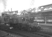 Ivatt 2-6-2T no 41285 is Carlisle station pilot on 30 January 1965. In the background Britannia Pacific no 70039 <I>Sir Christopher Wren</I> is about to take the 9am Perth - Euston out of platform 4.<br><br>[K A Gray 30/01/1965]