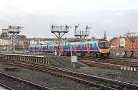 Six of the eight semaphore signals that control departures from the platforms at Blackpool North are seen here on 13th November 2013. They will not survive electrification, due for completion in May 2016. TPE 185107 leaves Platform 7 with the hourly Manchester Airport service.<br><br>[Mark Bartlett 13/11/2013]