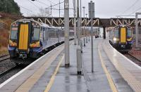 Platform view at Carstairs on a wet and overcast 26 November 2013. On the left is 380104 with the 11.48 Glasgow Central - Edinburgh Waverley service, while to the right is 380101 on the reverse working.<br><br>[Bill Roberton 26/11/2013]