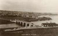 A postcard overview of Banff Bridge station, penultimate station on the Macduff line from Inveramsay. The terminus of the line from Grange at Banff was nearby, across the river in the far distant right. Banff Bridge station was on the GNSR's 1872 extension from the 'Macduff (Banff)' terminus to Macduff.<br><br>[Ewan Crawford Collection //]