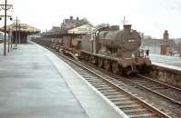 A ballast train clatters westbound through Basingstoke station on 24 August 1964.  The train is hauled by Guildford shed's Maunsell Q class 0-6-0 no 30542.<br><br>[John Robin 24/08/1964]