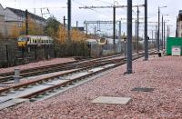 Looking west along the tram line at Haymarket Yards towards Murrayfield  on 3 December 2013, with class 334 and 221 units passing on the main line.<br><br>[Bill Roberton 03/12/2013]