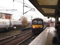 322484 enters Wakefield Westgate platform 2 with the 08.55 local service, ex Doncaster, to Leeds, whilst across at platform 1 the Flying Scotsman liveried DVT is at the front of the 08.56 East Coast service to Kings Cross.<br><br>[David Pesterfield 28/11/2013]