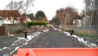 View north from a point near the site of the former Hardengreen Junction on 18 December 2013. The remains of the original 1847 Eskbank station lie immediately beyond the A6094 road bridge in the background. The houses of Hardengreen Lane stand on the left. [See image 17896]<br><br>[John Furnevel 18/12/2013]