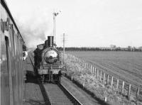 Photograph taken from a window of SLS/BLS <I>Scottish Rambler no 2</I> on 15 April 1963. The train was on its way back from Stranraer Town to Glasgow St Enoch (behind HR103 + GNSR49) when it passed Stranraer shed's 57375 west of Dunragit. The <I>Jumbo</I> had earlier taken the special from Newton Stewart along the Garlieston and Whithorn branches and is seen here on its way home.<br><br>[John Robin 15/04/1963]