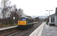 An unusual visitor to the Highlands on a dreich New Years Eve 2013. Class 56 No.56312 <i> Jeremiah Dixon </i>  passes through a very wet Carrbridge Station on its way south from Inverness. [The full nameplate reads: Jeremiah Dixon - Son of County  Durham - Surveyor of the Mason-Dixon Line U.S.A.]<br><br>[John Gray 31/12/2013]