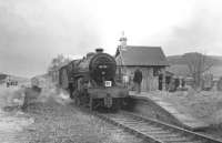 42737 at Broughton on 29 March 1964 with <I>Scottish Rambler no 3</I>. The <I>Crab</I> had brought the special from Symington to what was then the limit of the former route to Peebles (the line east having closed in 1954). This surviving section had been retained to serve a nearby meat processing facility. On the left is the old island platform built in 1896 to serve the Talla Railway [see image 6635]. <br><br>[John Robin 29/03/1964]