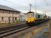 Freightliner 66555 takes coal empties from Fiddlers Ferry Power Station to Hunterston through Carnforth on 9 January 2014. The train is just passing the area Network Rail office. In the foreground is a surviving remnant of the old main line Down platform. <br><br>[Mark Bartlett 09/01/2014]