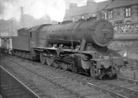 One of Grangemouth sheds large WD Austerity 2-10-0s, no 90765, rumbles past Larbert North signal box with an up freight in 1962.<br><br>[David Stewart //1962]