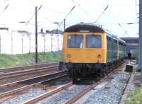 A Cravens (Class 105) and BRC&W (Class 104) combination passes a Temporary Speed Restriction sign as it runs on to new Down Slow track just north of Leyland in 1981. These Newton Heath sets are heading for Preston and Blackpool. The WCML is not so accessible nowadays, protected here by palisade fencing.<br><br>[Mark Bartlett 10/06/1981]